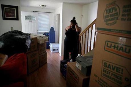 FOR DAVID SCHARFENBERG HOUSING STORY PLEASE DO NOT PUBLISH PRIOR 06/18/2016 -Boston, MA- Shantel Young (cq) looks over the living room of her new home in the Dorchester neighborhood of Boston, MA on June 18, 2016. She and her husband Rob and their two children moved from a two bedroom apartment to a three bedroom home just over a mile apart in Dorchester. Shantel said she is looking forward to having more room, 