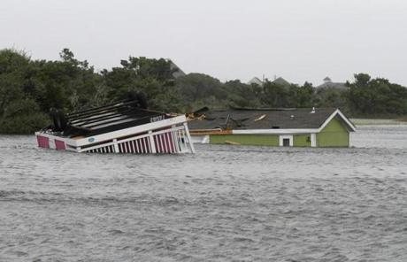 Two trailers sit overturned in the creek behind the Hatteras Sands Campground in Hatteras, N.C., Saturday, Sept. 3, 2016 after Tropical Storm Hermine passed the Outer Banks. The storm is expected to dump several inches of rain in parts of coastal Virginia, Maryland, Delaware, New Jersey and New York as the Labor Day weekend continues. (AP Photo/Tom Copeland)
