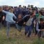 FILE - In this Tuesday Sept. 8, 2015 file photo taken from TV, a Hungarian camerawoman, center left in blue, kicks out at a young migrant who had just crossed the border from Serbia near Roszke Hungary. Petra Laszlo, the camerawoman who was filmed kicking and trying to trip migrants near Hungaryâ??s border with Serbia in September 2015 has been indicted for breaching the peace, Hungarian prosecutors said Wednesday Sept. 7, 2016. (Index.Hu. via AP/File) HUNGARY OUT