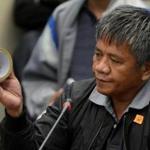 Edgar Matobato holds a roll of tape, the type of which he says he used on his victims, during a Senate hearing.
