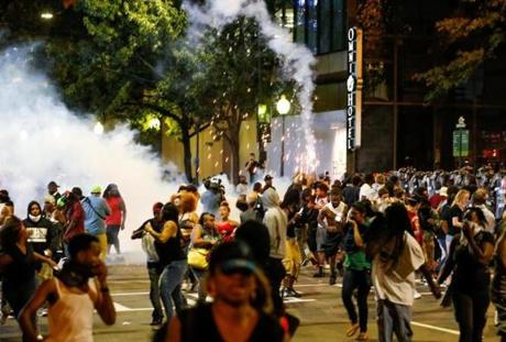 People run from flash-bang grenades in uptown Charlotte, NC during a protest of the police shooting of Keith Scott, in Charlotte, North Carolina, U.S. September 21, 2016. REUTERS/Jason Miczek
