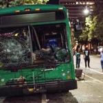 CHARLOTTE, NC - SEPTEMBER 22: Demonstrators walk near a damaged bus on September 22, 2016 in downtown Charlotte, NC. The North Carolina governor has declared a state of emergency in the city of Charlotte after clashes during protests in the city in response to the fatal shooting by police officers of 43-year-old Keith Lamont Scott at an apartment complex near UNC Charlotte. (Photo by Sean Rayford/Getty Images)