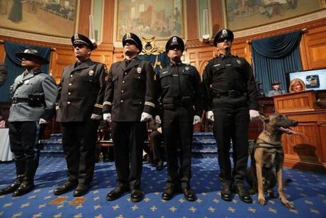 Medal of Valor winners (left to right) Trooper Nathan R. Monteiro, Bourne Detective Sergeant John R. Stowe Jr., Sergeant Wallace J. Perry IV, and Officer Joshua A. Parsons were joined by Bourne officer Jared P. MacDonald and his service dog, Bullet. MacDonald was shot in the line of duty and is retiring. 
