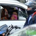 An Indian commuter protected her face from dust and pollution at a busy traffic junction in Bangalore Tuesday. 