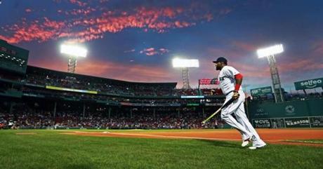 09/14/16: Boston, MA: Red Sox DH David Ortiz will soon be riding off into the sunset as far as his major league baseball career is concerned, tonight he is just heading back into the dugout as the sun sets over Fenway Park after finishing some pre game warmups. The Boston Red Sox hosted the Baltimore Orioles in a regular season MLB baseball game at Fenway Park. (Globe Staff Photo/Jim Davis) section: metro topic: Red Sox-Orioles 
