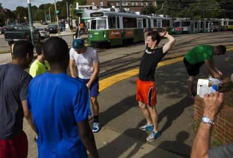 Boston, MA - 09/18/2016 - A group of runners that race against MBTA Green line trains along Commonwealth Avenue, talk as they stretch before the start of their race againsg the train in Boston, MA, September 18, 2016. The runners ran along the train's route on Commonwealth Avenue from the Boston College stop to the Blandford Street stop with the fastest time beating the train to the station by 6 minutes and 15 seconds. (Keith Bedford/Globe Staff) 
