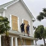 Workers from Armstrong Construction put plywood over windows of a home in preparation for Hurricane Matthew Wednesday, Oct. 5, in Ponte Vedra Beach, Fla. People boarded up beach homes, schools closed and officials ordered evacuations along the East Coast on Wednesday as Hurricane Matthew tore through the Bahamas and took aim at Florida, where the governor urged coastal residents to 