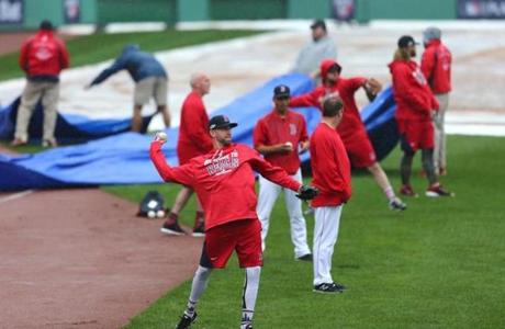 Boston, MA 10/09/16 Red Sox pitchers warm up while the ground crew puts tarp down on the field at Fenway Park Sunday, Oct. 9, 2016. Game three of ALDS between the Boston Red Sox and Cleveland Indians was cancelled due to rain. (John Tlumacki/Globe Staff)
