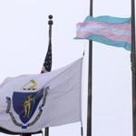 A flag representing the transgender community, right, flies next to the Massachusetts state flag, left, and an American flag, behind, in front of Boston City Hall, Monday, May 2, 2016, in Boston. Democratic Boston Mayor Marty Walsh, a supporter of transgender rights, said Monday the flag will continue to fly until everyone is equal under the law in Massachusetts. (AP Photo/Steven Senne)