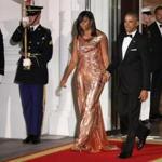 President Barack Obama and first lady Michelle Obama walk to North Portico at the White House in Washington, Tuesday, Oct. 18, 2016, to greet Italian Prime Minister Matteo Renzi and his wife Agnese Landini, for a State Dinner. The first lady is wearing a floor length, rose gold chainmail gown designed by Atelier Versace. (AP Photo/Manuel Balce Ceneta)