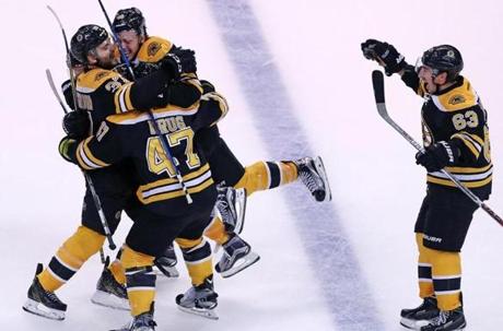 10/20/16: Boston, MA: The Bruins Patrice Bergeron (left) is mobbed by teammates David Pastrnak, Torey Krug and Brad Marchand after he beat Devils goalie Cory Schneider late in the third period for the game winning goal. The Boston Bruins hosted the New Jersey Devils in an NHL hockey game at the TD Garden. It was their regular season home opener. (Globe Staff Photo/Jim Davis) section: sports topic: Bruins-Devils
