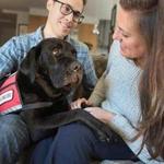 Jessica Kensky and her husband, Patrick Downes, play with Rescue, a service black Labrador.