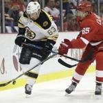 Red Wings defenseman Danny DeKeyser (65) tried to steal the puck from Bruins left wing Brad Marchand (63).