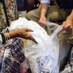 10/13/2016 MATTAPAN, MA Jesse Edsell-Vetter (cq) (right), Hoarding Intervention Program Manager, helps his client sort through clothing during a site visit at a home in Mattapan. The client tosses a dress into a bag to be removed. (Aram Boghosian for The Boston Globe) 