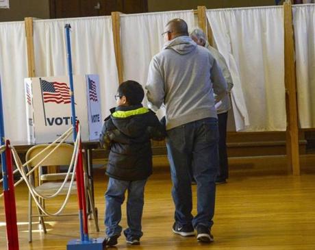 Norman Marquez, of Winchester, N.H., holds the hand of his 5-year-old son, Daniel, as they head into the voting booth to cast their ballot at the Winchester Polling Station on Tuesday, Nov. 8, 2016.(Kristopher Radder/The Brattleboro Reformer via AP)
