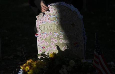 A woman places a voting sticker on the headstone of Susan B. Anthony, a women's suffrage pioneer, on Election Day in Rochester, N.Y., Nov. 8, 2016. On Tuesday, Anthony's gravestone was nearly invisible beneath a coating of â??I Votedâ?? stickers and behind a line of hundreds of people who came here to pay their respects. (Katherine Taylor/The New York Times)

