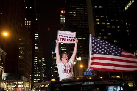 A supporter of U.S. Republican presidential candidate Donald Trump cheers near the intersection of West 54th Street and Fifth Avenue in New York, U.S. November 9, 2016. REUTERS/Alex Wroblewski
