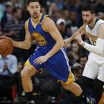 Golden State Warriors guard Klay Thompson, left, picks upthe ball in front of Denver Nuggets center Jusuf Nurkic, of Bosnia, in the first half of an NBA basketball game Thursday, Nov. 10, 2016, in Denver. (AP Photo/David Zalubowski)