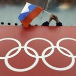 FILE - In this Feb. 18, 2014 file photo, a Russian skating fan holds the country's national flag over the Olympic rings before the start of the men's 10,000-meter speedskating race at Adler Arena Skating Center during the 2014 Winter Olympics in Sochi, Russia. The Olympic world is bracing for more evidence of systematic Russian doping. World Anti-Doping Agency investigator Richard McLaren is releasing his latest report on Friday Dec. 9, 2016 into allegations of state-sponsored cheating and cover-ups in Russia. (AP Photo/David J. Phillip, file)