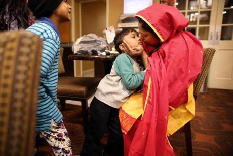 Rizwan Shahorin, 7, watched as his brother Imtiaz Fiad, 4, was comforted by their mother Sahida Akter, while having dinner at the Holiday Inn Express, where they are staying.
