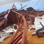 In this image made from video taken on Saturday, local people surveyed the scene after a church roof collapsed in Uyo, Nigeria.