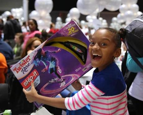 Boston, MA--12/20/2015--Gianna Gomez (cq), 8, of Roxbury, is delighted with her Twister game. The 27th annual Christmas in the City celebration and Winter Wonderland is held Sunday, December 20, 2015 (cq). Photo by Pat Greenhouse/Globe Staff Topic: 21christmascity Reporter: Astead Herndon 
