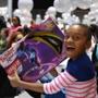Boston, MA--12/20/2015--Gianna Gomez (cq), 8, of Roxbury, is delighted with her Twister game. The 27th annual Christmas in the City celebration and Winter Wonderland is held Sunday, December 20, 2015 (cq). Photo by Pat Greenhouse/Globe Staff Topic: 21christmascity Reporter: Astead Herndon 