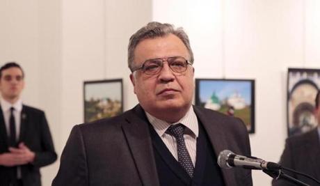 The Russian Ambassador to Turkey Andrei Karlov speaks a gallery in Ankara Monday Dec. 19, 2016. A gunman opened fire on Russia's ambassador to Turkey Karlov at a photo exhibition on Monday. The Russian foreign ministry spokeswoman said he was hospitalized with a gunshot wound. The gunman is seen at rear on the left. (AP Photo/)
