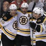 Boston Bruins center Patrice Bergeron (37) celebrates his second period goal with teammates David Pastrnak (88), Brad Marchand (63), obscured, and Torey Krug (47) during play against the Florida Panthers in an NHL hockey game, Thursday, Dec. 22, 2016, in Sunrise, Fla. (AP Photo/Joe Skipper)