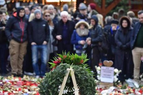 People mourn at a makeshift memorial for the victims of the Christmas market attack near the Kaiser-Wilhelm-Gedaechtniskirche (Kaiser Wilhelm Memorial Church) in Berlin on December 24, 2016. Germany hunts for possible accomplices of the suspected Berlin truck attacker Anis Amri, who was shot dead by Italian police in Milan on Friday, December 23, 2016. The Islamic State group has claimed responsibility for this week's attack on a Berlin Christmas market, in which 12 people were killed and dozens more wounded. / AFP PHOTO / John MACDOUGALLJOHN MACDOUGALL/AFP/Getty Images
