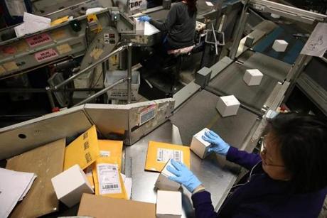 SAN FRANCISCO, CA - DECEMBER 18: U.S. Postal worker Winnie Hong moves packages onto a conveyor belt at the U.S. Post Office sort center on December 18, 2014 in San Francisco, California. The U.S. Postal Service will process and mail over one billion cards, letters and packages during the 2014 holiday season. (Photo by Justin Sullivan/Getty Images)
