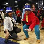 Silvina Cardoso, 84, of Dorchester got low with Margarida Tavares from the Cape Verdean Adult Day Program in Dorchester during Seniors First Night at the Seaport World Trade Center on Thursday.