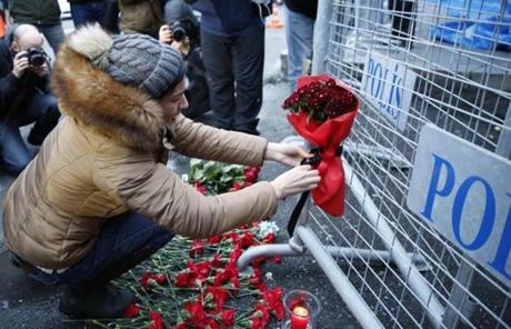 epa05694414 People place flowers and candles at a police barrier in front of the Reina night club following a gun attack at the popular night club in Istanbul close to the Bosphorus river, in Istanbul, Turkey, 01 January 2017. At least 39 people were killed and 65 others were wounded in the attack, local media reported. EPA/DENIZ TOPRAK
