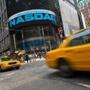 Taxi cabs drive past the Nasdaq MarketSite in New York's Times Square.