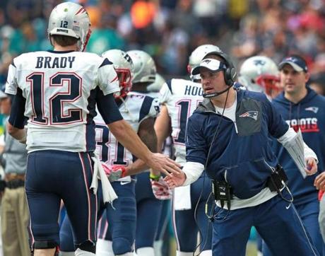 Miami Gardens, FL 1-1-17: Patriots offensive coordinator Josh McDaniels greets quarterback Tm Brady (12) after the 77 yard catch and run touchdown that Brady and Julian Edelman combined on. The New England Patriots visited the Miami Dolphins in a regular season NFL football game at Hard Rock Stadium. (Globe Staff Photo/Jim Davis) reporter: mcbride topic: Patriots 

