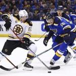 Boston Bruins' Brad Marchand, left, attempts to gain control of the puck as he is pressured by St. Louis Blues' Colton Parayko during the first period of an NHL hockey game Tuesday, Jan. 10, 2017, in St. Louis. (AP Photo/Billy Hurst)