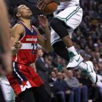 Boston, MA 1-11-17: The Celtics Isaiah Thomas (right) gets some air as he drives on the Wizards Otto Porter, left, second quarter action. The Boston Celtics hosted the Washington Wizards in a regular season NBA basketball game at the TD Garden. (Globe Staff Photo/Jim Davis) reporter: himmelsbach topic: Celtics-Wizards 