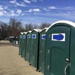 A row of portable restrooms, with the name Don?s Johns covered up.