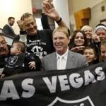 FILE - In this April 28, 2016, file photo, Oakland Raiders owner Mark Davis, center, meets with Raiders fans after speaking at a meeting of the Southern Nevada Tourism Infrastructure Committee in Las Vegas. The Raiders have filed paperwork to move to Las Vegas. Clark County Commission Chairman Steve Sisolak told The Associated Press on Thursday, Jan. 19, 2017, that he spoke with the Raiders. (AP Photo/John Locher, File)