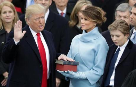 WASHINGTON, DC - JANUARY 20: (L-R) U.S. President Donald Trump takes the oath of office as his wife Melania Trump holds the bible and his son Barron Trump looks on, on the West Front of the U.S. Capitol on January 20, 2017 in Washington, DC. In today?s inauguration ceremony Donald J. Trump becomes the 45th president of the United States. (Photo by Chip Somodevilla/Getty Images)

