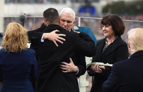 US Vice President Mike Pence hugs his son Michael as Karen Pence (R) watches during the Presidential Inauguration at the US Capitol in Washington, DC, on January 20, 2017. / AFP PHOTO / POOL / SAUL LOEBSAUL LOEB/AFP/Getty Images
