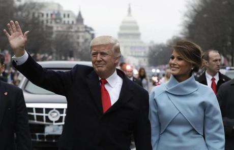 President Donald Trump waves as he walks with first lady Melania Trump during the inauguration parade on Pennsylvania Avenue in Washington, Friday, Jan. 20, 2016. (AP Photo/Evan Vucci, Pool)
