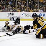 Penguins forward Sidney Crosby (87) was on his knees but still tried to put the puck past Bruins defenseman Torey Krug (47) and goalie Tuukka Rask.