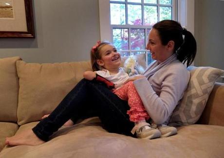 At their home in Brookline, Dawn Oates cuddled with her daughter Harper, who born with a spinal cord injury that left her a quadriplegic. Harper, 5, was denied a spot last year at the Park School.
