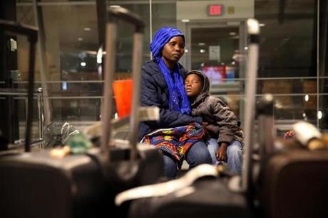 Manchester, NH - February 02, 2017: Vanisi Vzamukunda comforts her sleepy daughter Sarah, 7, while waiting for their baggage at the Manchester?Boston Regional Airport in Manchester, NH on February 02, 2017. Members of the International Institute of New England - Lowell greeted the Congolese of seven and escorted them to their new home. . The family is originally from the Democratic Republic of the Congo but spent time in Uganda before coming to the United States. (Refugee organizations managed to get one last batch of refugees into the US by arguing that they were already 