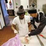 Culinary innovator Sam Putnam of Arlington (right) showed Jefferson Alvarez of Lawrence how to break down a chicken at Utec in Lowell.