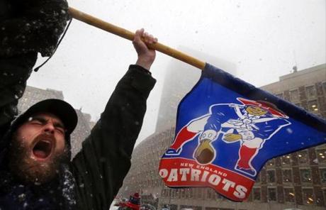 Boston, MA- February 07, 2017: Nick Overbought of Lynn carries a flag during the New England Patriots Super Bowl LI victory parade in Boston, MA on February 07, 2017. (Globe staff photo / Craig F. Walker) section: metro reporter: New England Patriots Super Bowl Parade 2017 boston globe staff 
