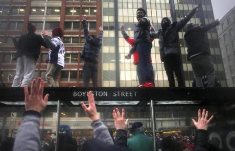 Boston, MA - 02/07/17 - Fans jumped up on a bus stop in Copley Square as fans line the route for the Patriots' 2017 Superbowl victory parade along Boylston Street in Boston. New England Patriots Super Bowl Parade 2017 boston globe staff (Lane Turner/Globe Staff) Reporter: (various) Topic: (08paradepic)
