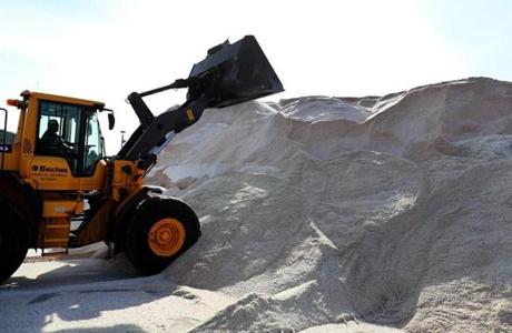 A front end loader worked on a huge road salt pile in Boston.
