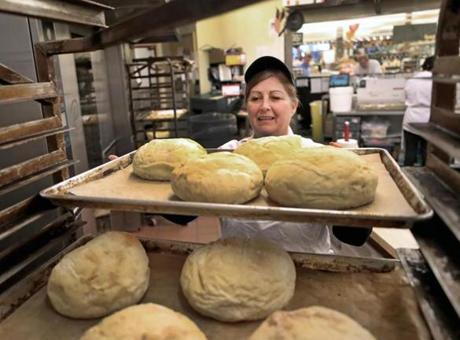 Bakery manager Cathy Curry loaded bread on to trays while working at the Roche Bros. store in Quincy.
